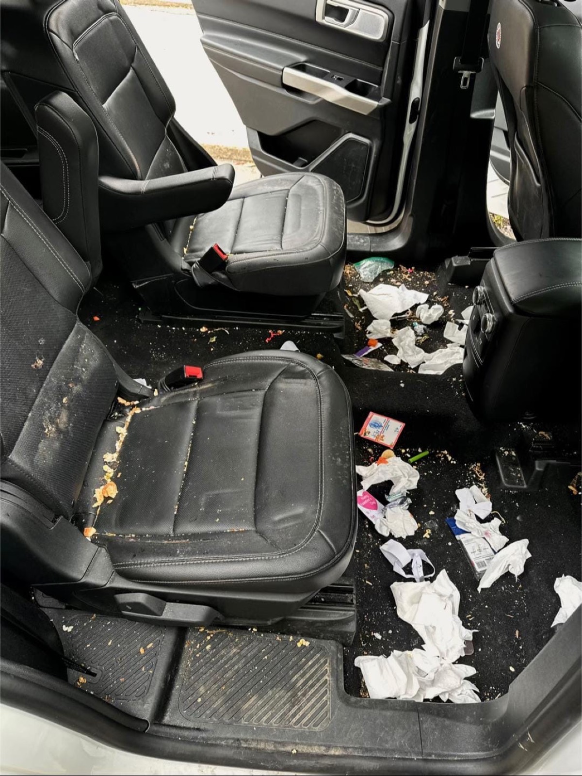 Before: Ford Explorer second row covered in food debris and trash — Plano, TX
